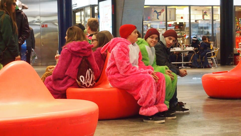 Fasnächtler in Kuscheltierkostümen auf einer Sitzbank im Luzerner Bahnhof.