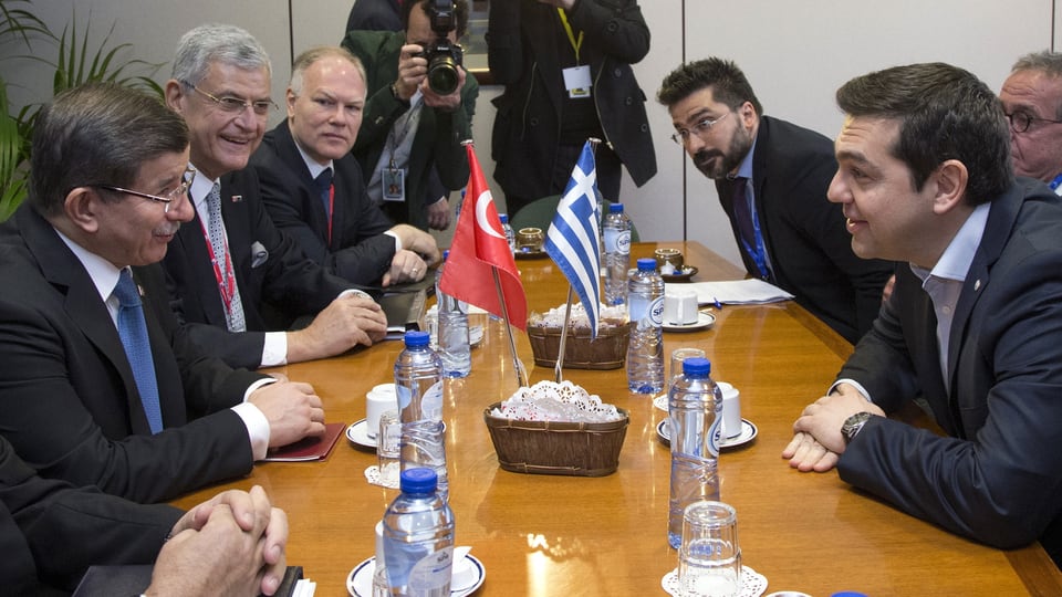 Davutoglu und Tsipras bei einem Vorab-Treffen in Brüssel. Andere Leute am Tisch.