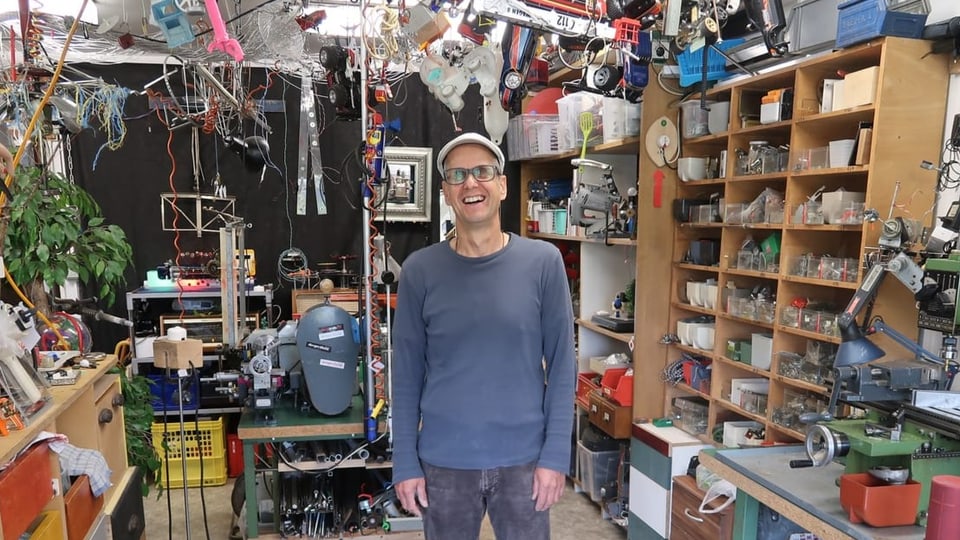 Künstler Martin Solèr in seinem Atelier, wo Kunstobjekte an der Decke hängen.