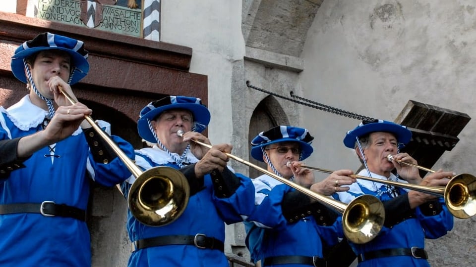 Männer in alten blau-weissen Uniformen und Fanfaren.