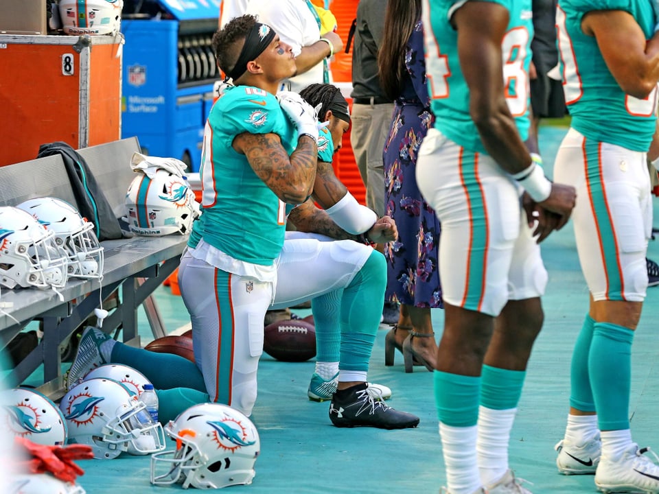 Kenny Stills, Wide Receivers bei den Miami Dolphins, kniet während der Hymne vor der Spielerbank.