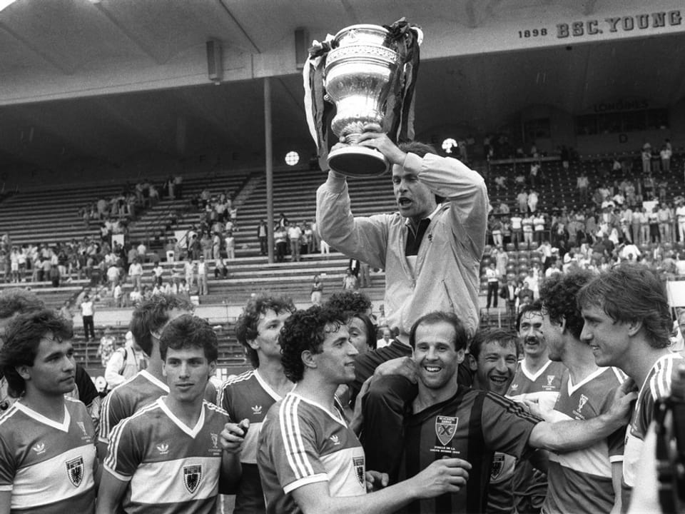 Hitzfeld mit Pokal, darunter Spieler (1985)