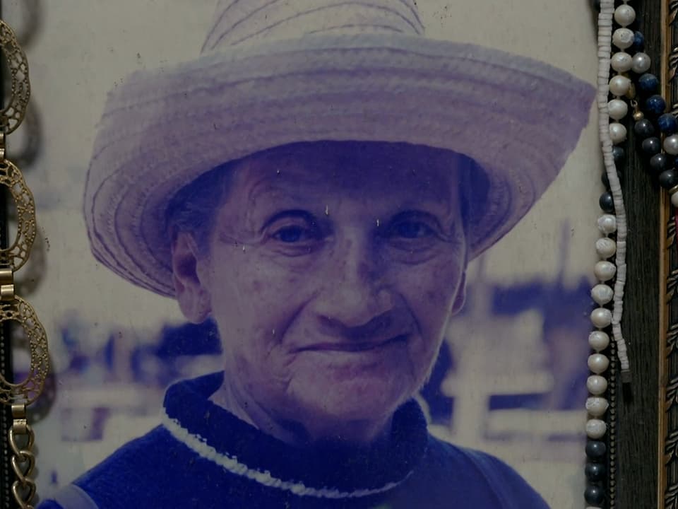 Eine gerahmtes Bild einer älteren Frau mit Strohhut.