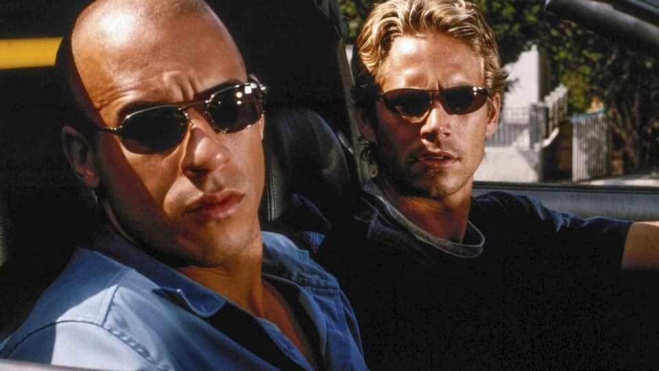 Zwei Männer mit Sonnenbrille in einem Auto. Es sind die Hollywoodstars