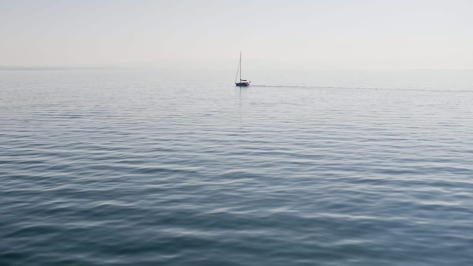 Ein einsames Segelschiff fährt auf dem Bodensee