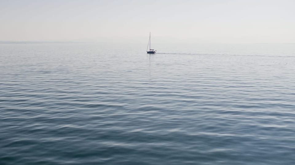 Ein einsames Segelschiff fährt auf dem Bodensee