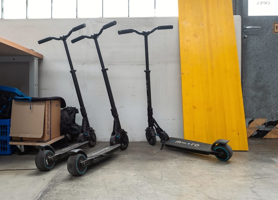 Drei Elektro-Scoote stehen in der Garage.