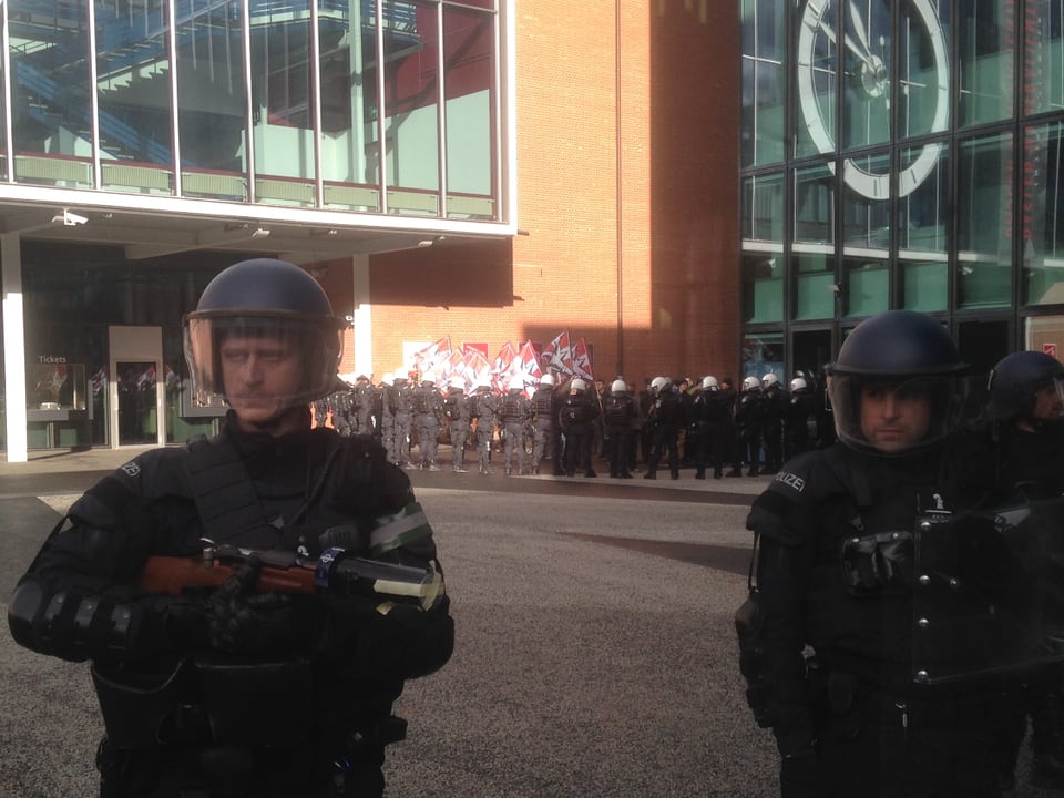 Zwei Polizisten vor der Messe, im Hintergrund weitere Polizisten