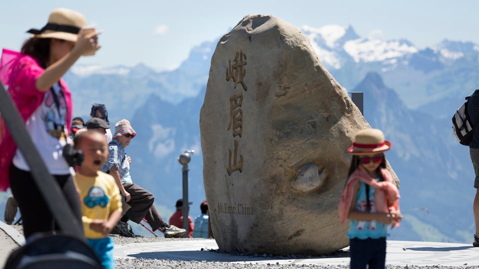 Felsbrocken des chinesischen Berg Emei Shan auf der Rigi. Daneben chinesische Turisten.