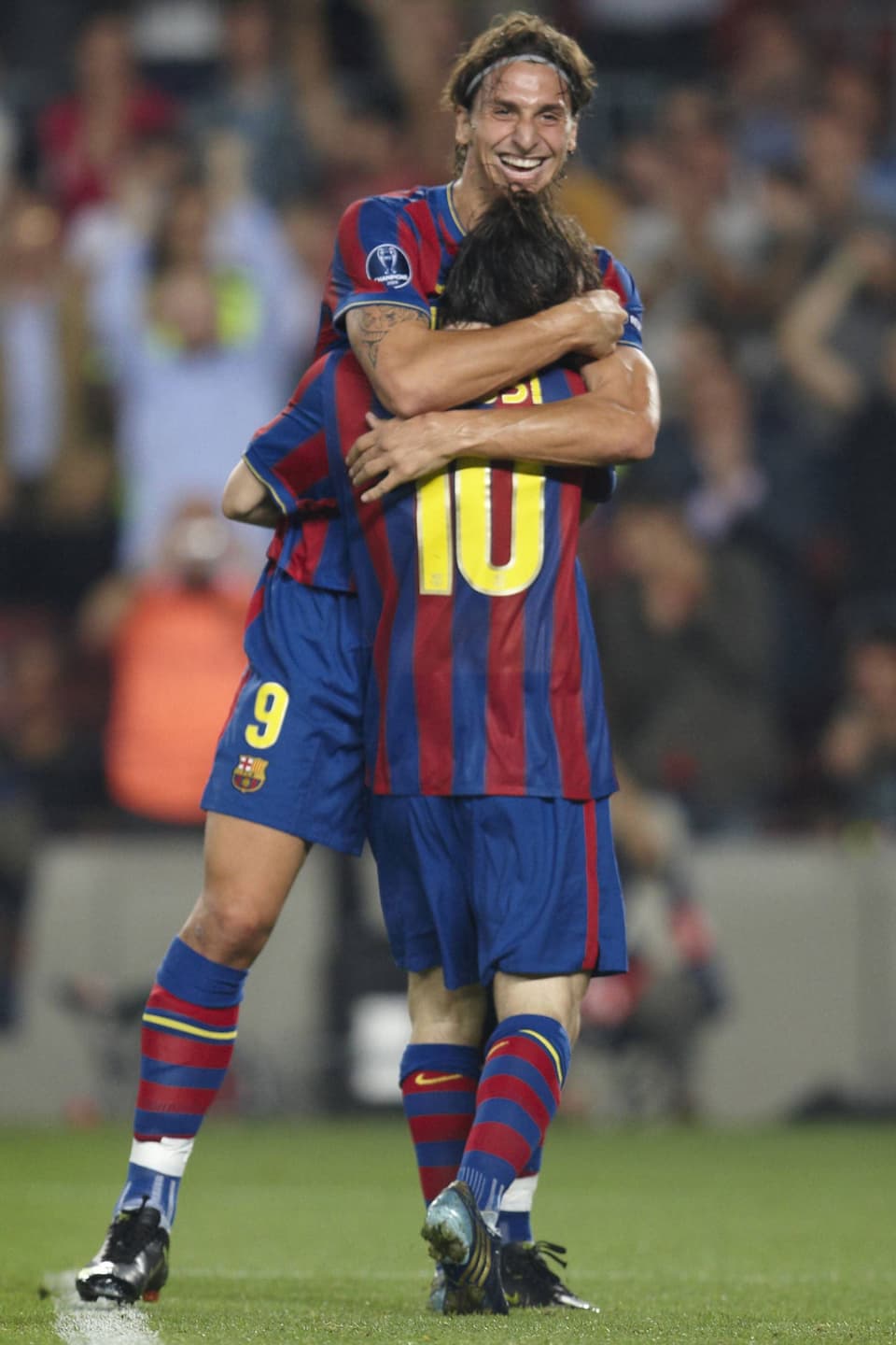 Zlatan Ibrahimovic umarmt Lionel Messi, beide tragen die Trikots des FC Barcelona. 