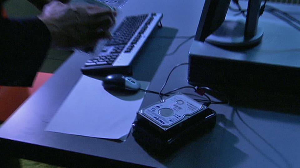 Eine externe Harddisk auf einem Schreibtisch mit Computer (Symbolbild).