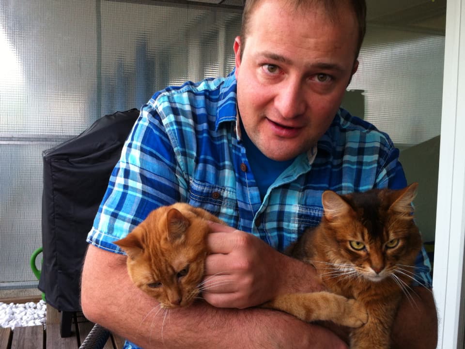 Michael Brunner und zwei Katzen.