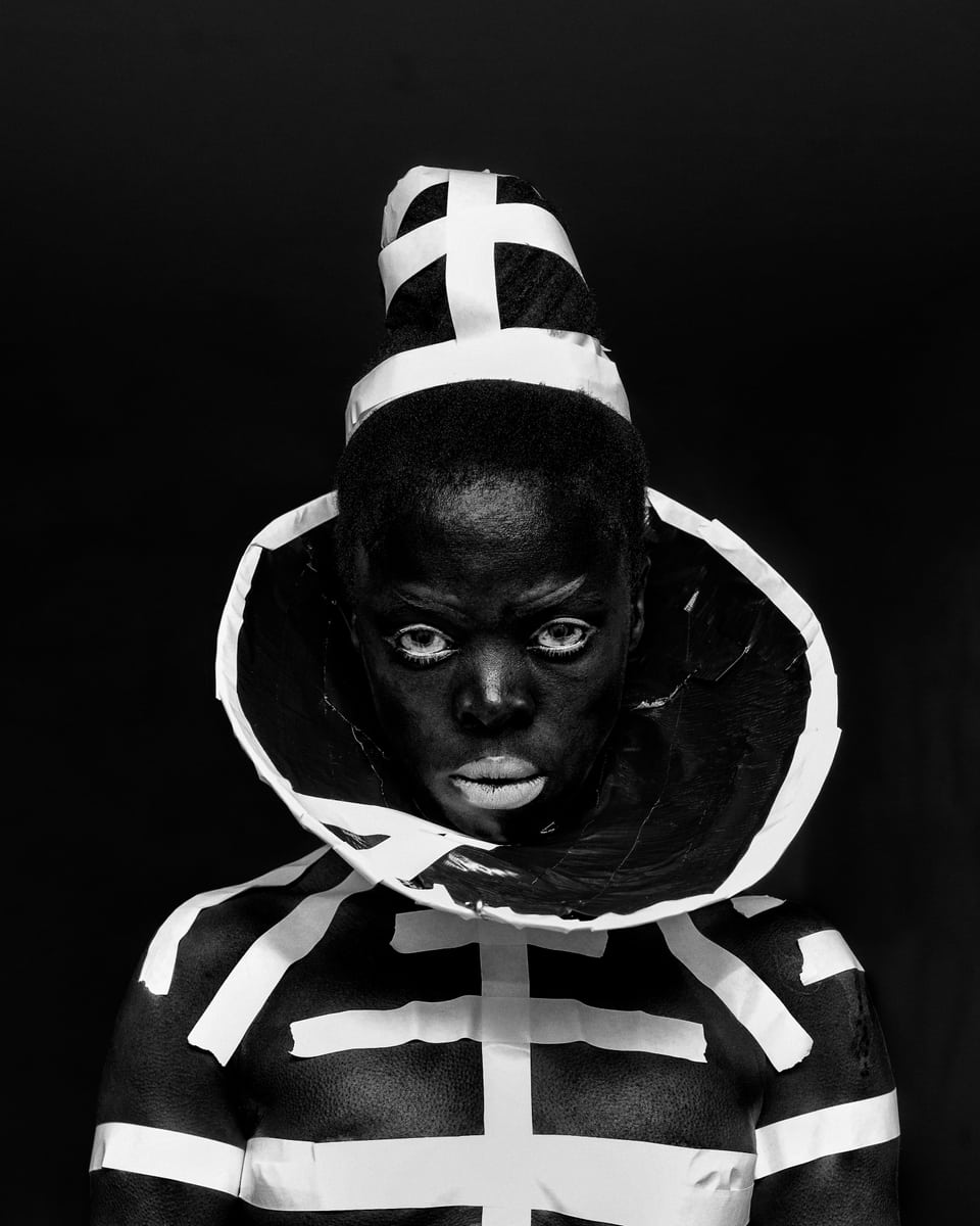 Schwarz-Weiss-Bild der Büste einer schwarzen Frau in einem Skelettähnlichem Outfit
