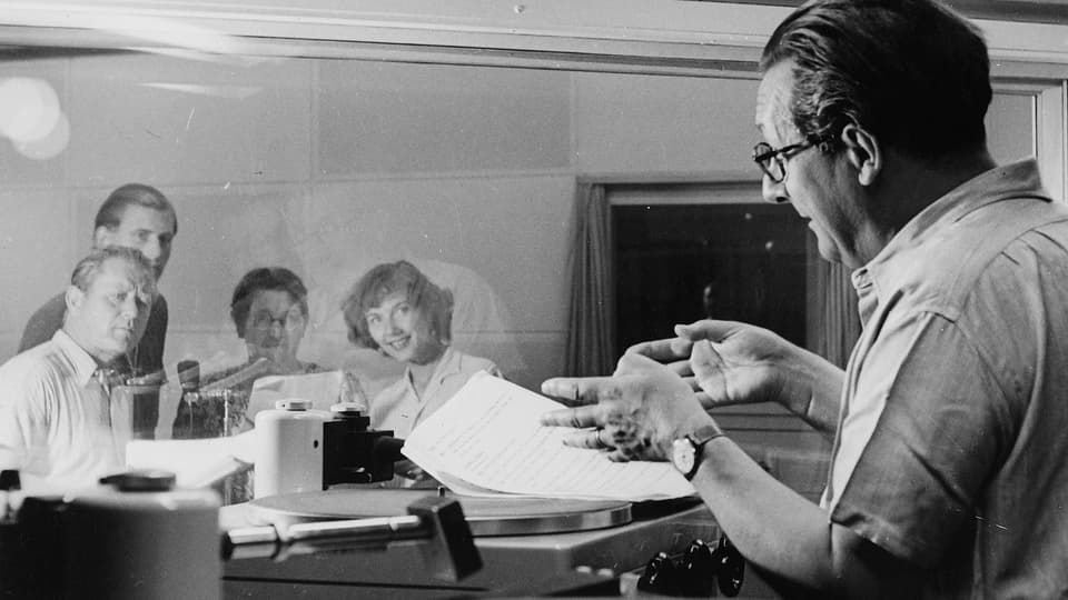 Hörspielaufnahmen von «Polizischt Wäckerli» (1950). Regisseur Artur Welti (rechts) gibt den Schauspieler*innen im Aufnahmeraum Anweisungen: v.l.n.r. Lee Ruckstuhl, Fritz Scheidegger, Schaggi Streuli und Lisa Ruckstuhl.