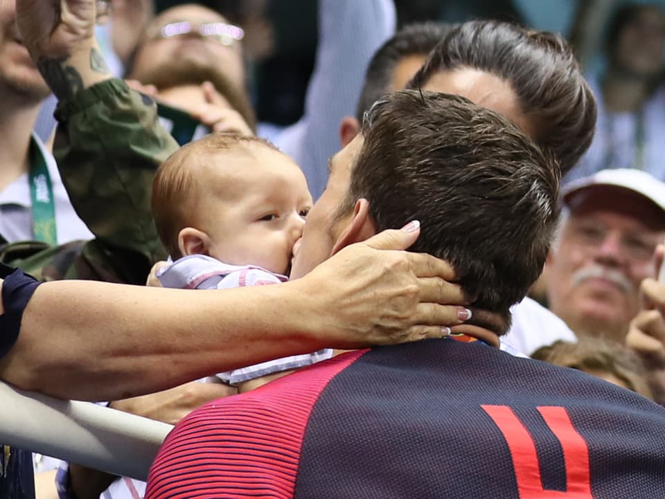 Michael Phelps küsst ein Baby.