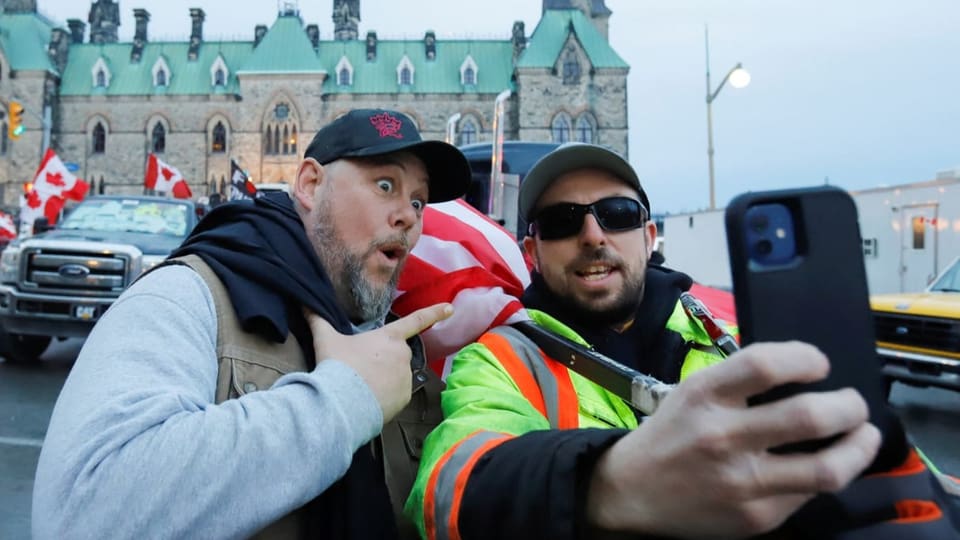 Zwei Trucker vor dem Rathaus von Ottawa machen ein Selfie mit dem Smartphone