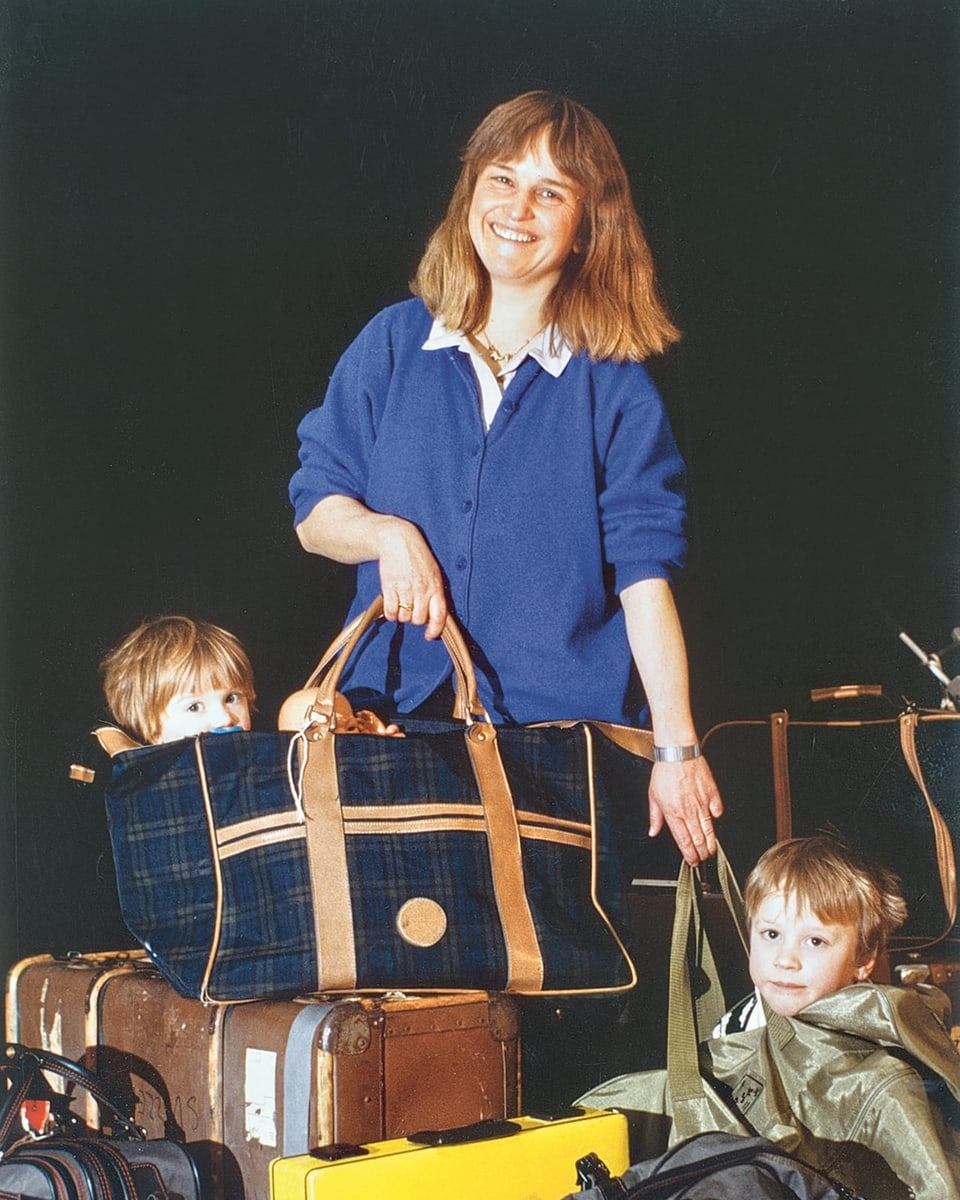 Eine Frau mit vielen Koffern, dazwischen zwei Kinder