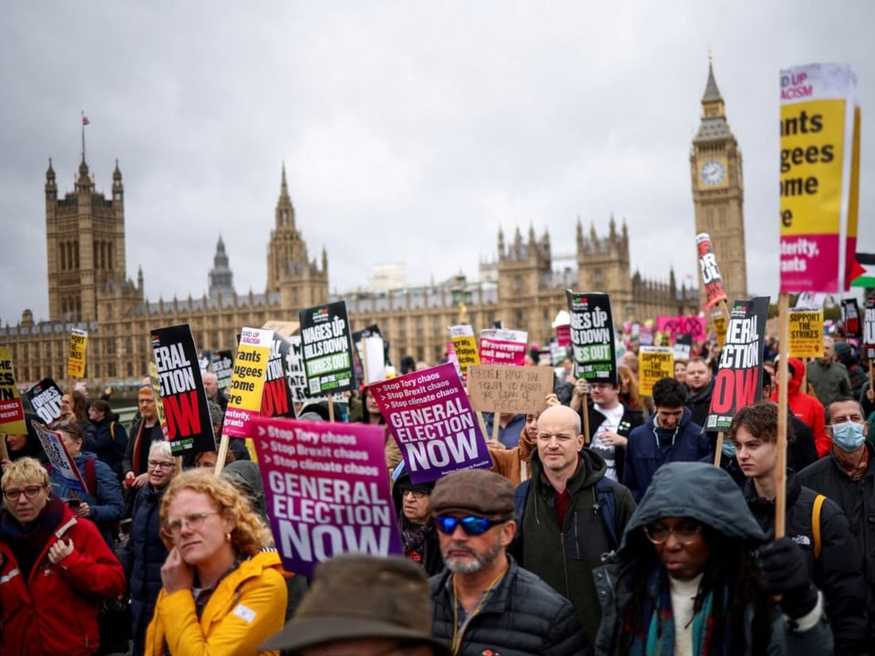 Menschen demonstrieren in London mit Plakaten.