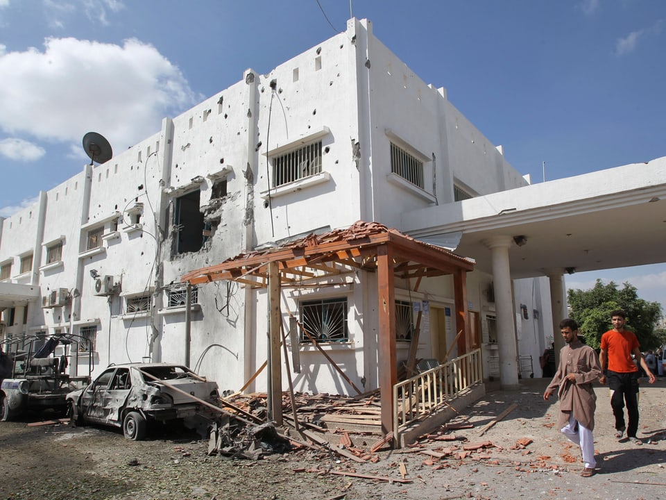 Zwei Palästinenser betrachten ein zerstörtes Spital.