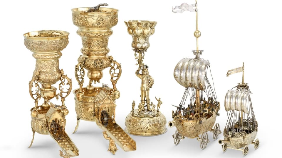 Fünf goldene und reich verzierte Trinkgefässe in Form von Pokalen und Segelschiffen. 