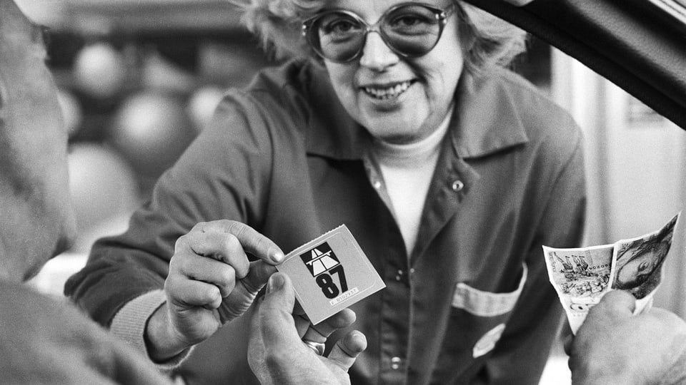 Eine Frau verkauft einem Autofahrer eine Autobahnvignette 87 für 30 Schweizer Franken. 