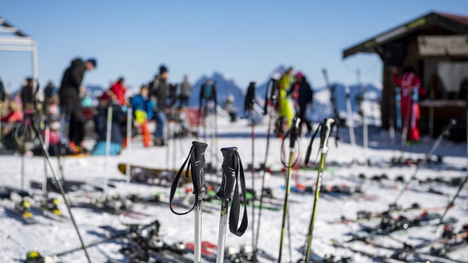 Skis und Skistöcke sind vor einem Restaurant im Schnee abgestellt.