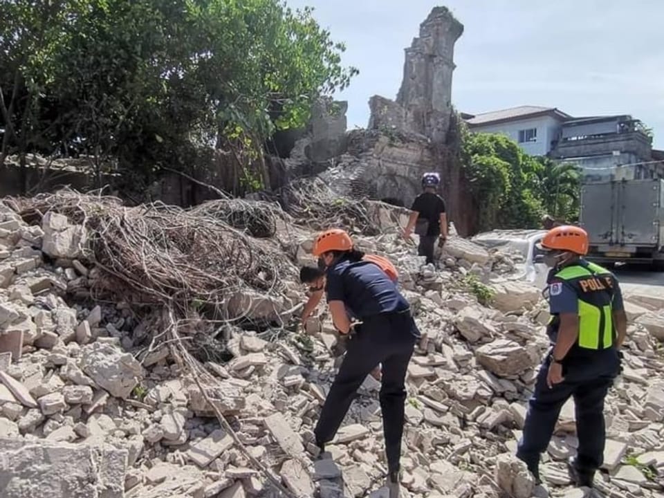 Rettungskräfte auf einem Trümmerfeld