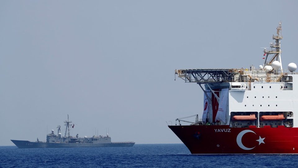Bohrschiff mit türkischem Emblem im Vordergrund, dahinter ein Kriegsschiff.
