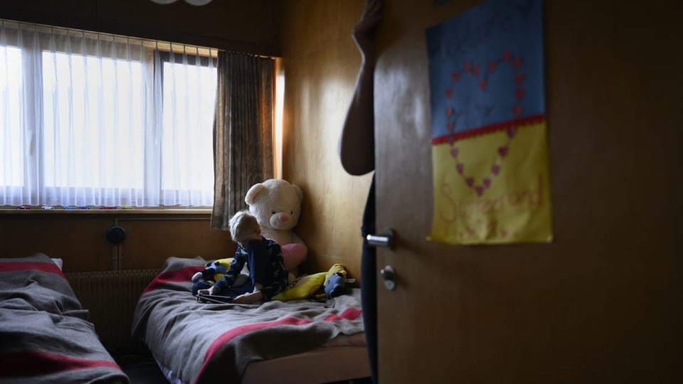 Ein ukrainisches Kind spielt auf einem Bett.