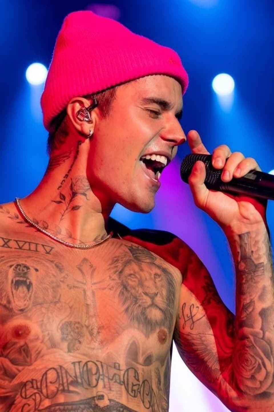Justin Bieber trägt eine pinke Mütze und ist Oberkörper frei
