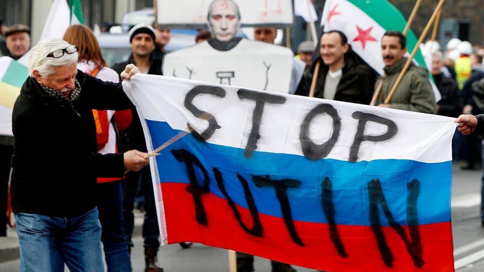 Polnische Demonstranten tragen eine russische Fahne mit der Aufschrift «STOP PUTIN».