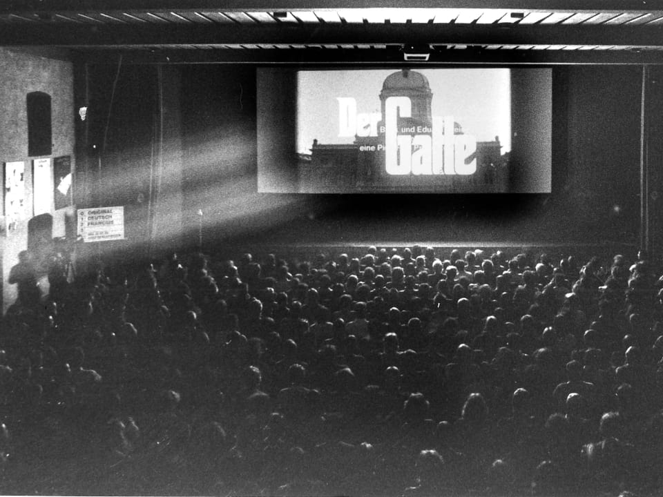 Ein Kinosaal, auf der Leinwand läuft der Film «Der Gatte».