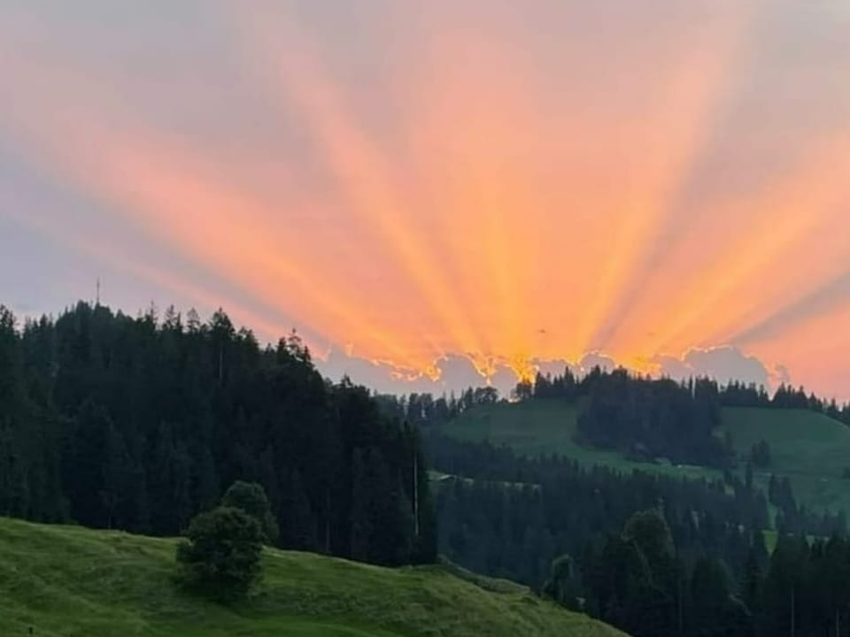 Strahlenbündel am Himmel der untergehenden Sonne.