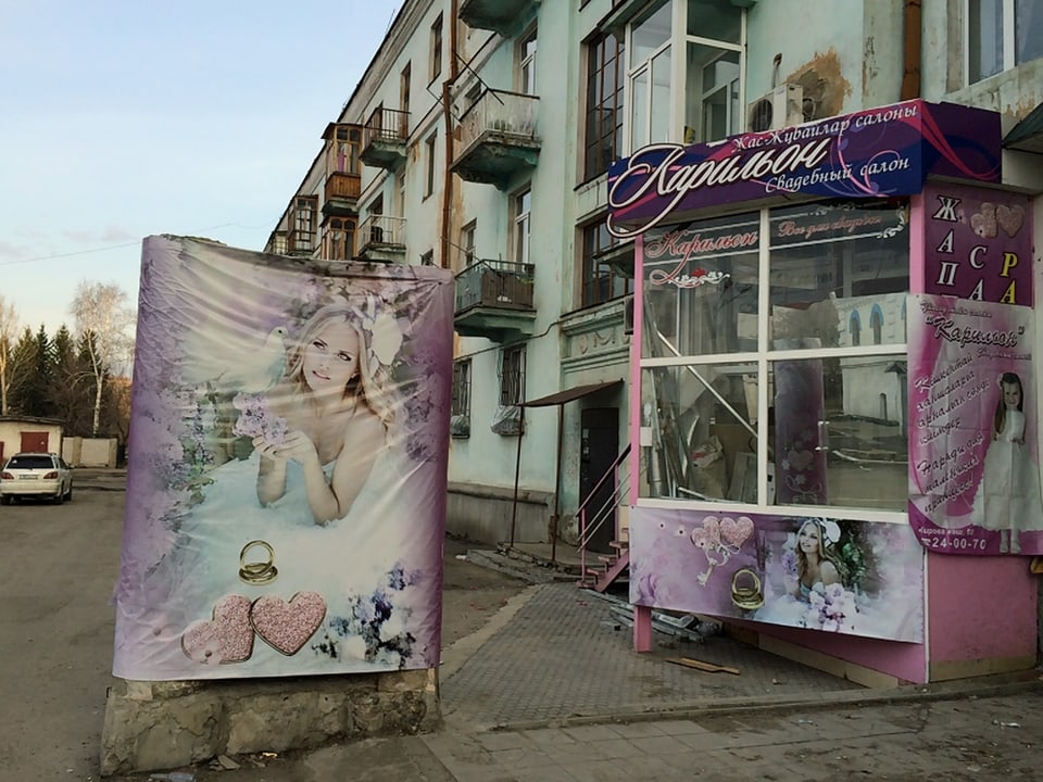 Häuserfront und Werbeplakate in Ust-Kamenogorsk.