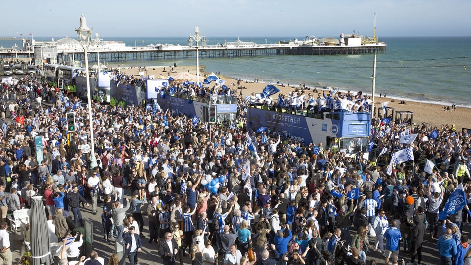 Die Spieler von Brighton & Hove Albion lassen sich bei einer Parade am Meer von den Fans feiern.