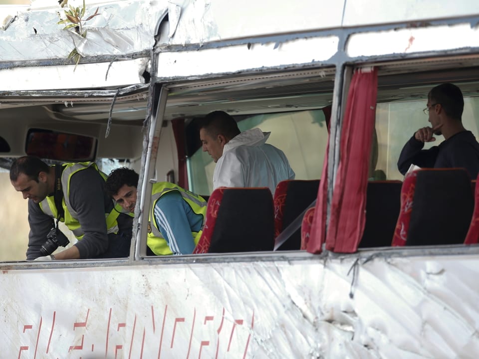 Forensiker untersuchen das Innere eines verunfallten Reisebusses. 