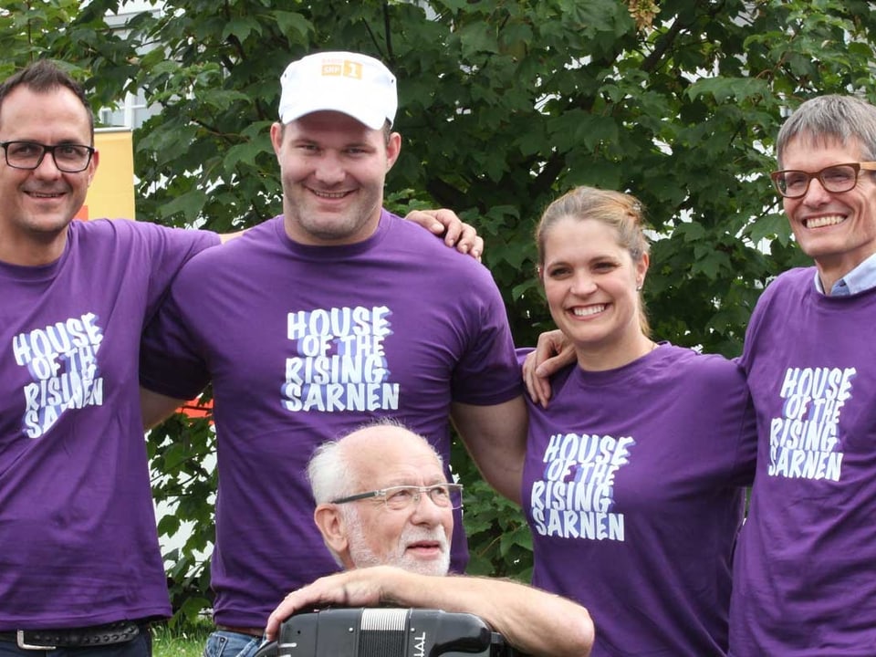 Vier Personen in violetten T-Shirts posieren fürs Bild.