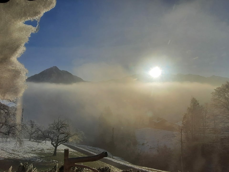Stanserhorn im Nebel mit Sonne im Hintergrund.
