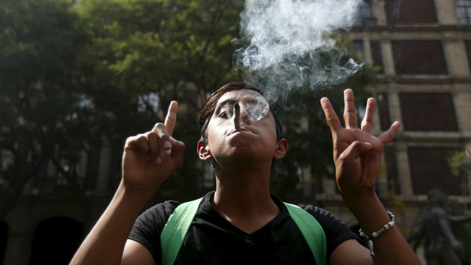 Ein junger Mexikaner raucht und gestikuliert.