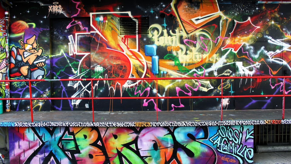 Wandmalerei ober- und unterhalb einer Brücke, in allen Farben. Unten der Schriftzug XBros.