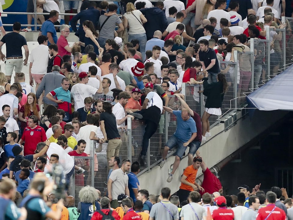 Englische Fans überklettern Zäune – und begeben sich in den Innenraum des Stadions.