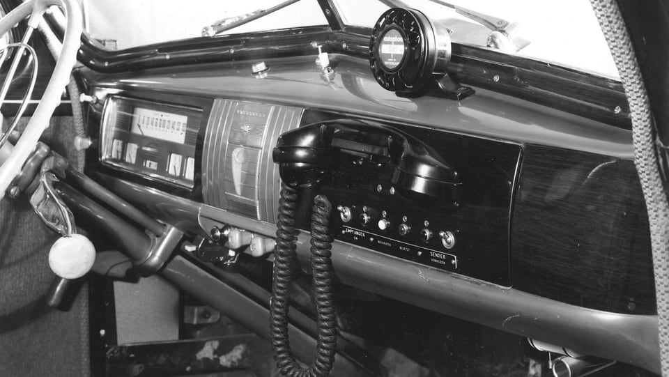 Telefonhörer und Wählscheibe an Auto-Armaturenbrett.