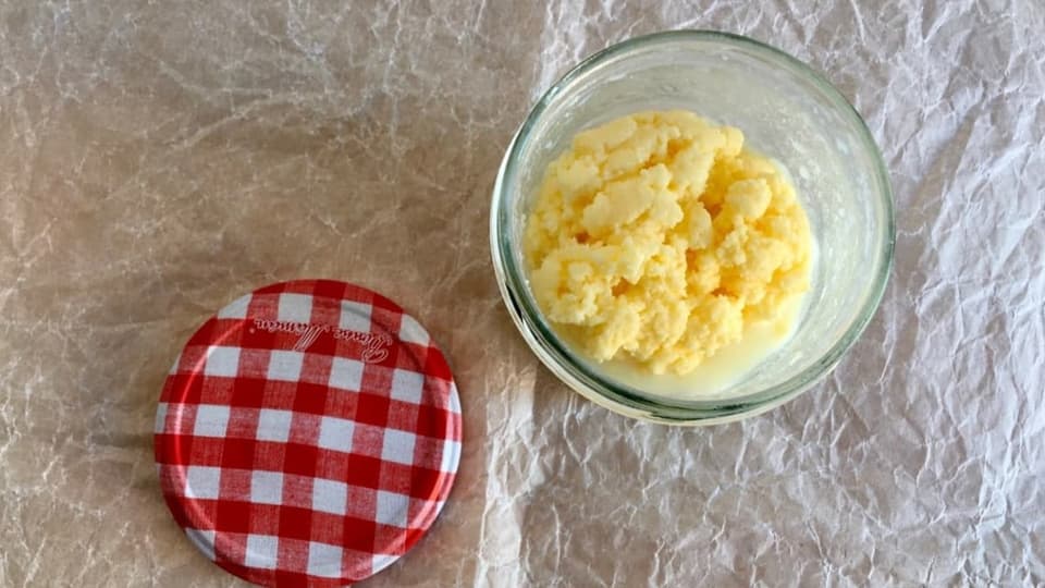Die Butter hat sich im Glas von der Buttermilch getrennt.
