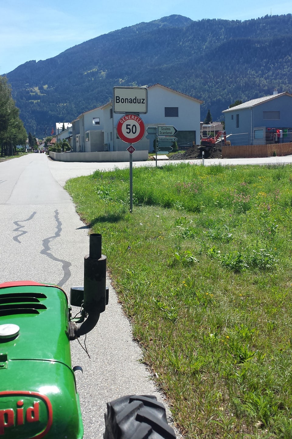 Der grüne Einachser vor dem Ortsschild von Bonaduz.