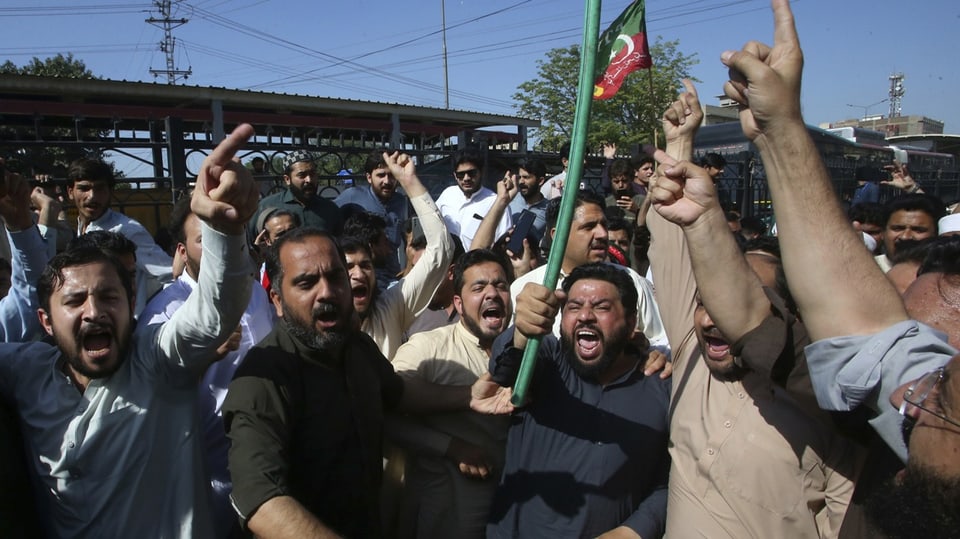 Anhänger Khans blockieren in Pakistan eine Strasse, um gegen die Verhaftung ihres Führers zu protestieren.