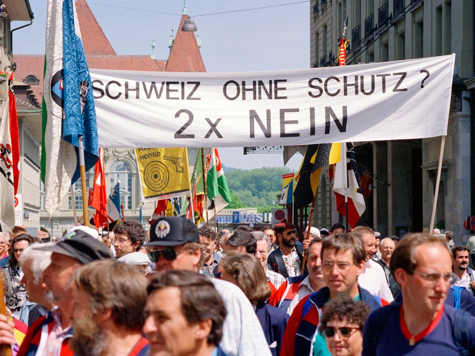 Demonstranten vor einem Banner.