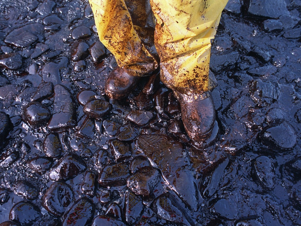 Ölverschmierte Schuhe an einem Strand.