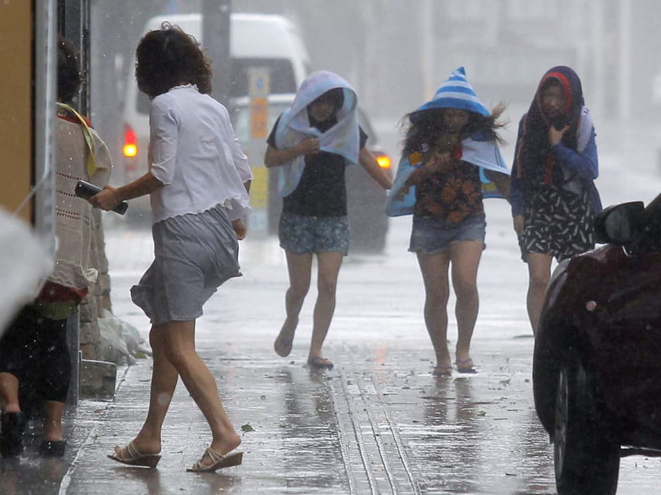 Japaner suchen Schutz vor dem Regen