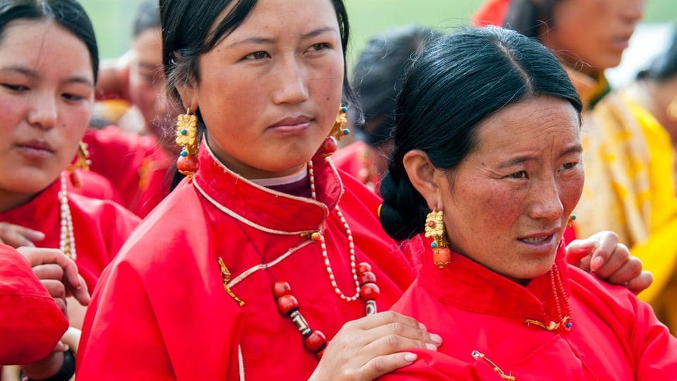 Women wearing festive clothes in Tibet at a festival.
