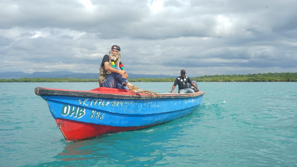 Reggae-Musiker Cedric Myton auf seinem Boot im Meer.